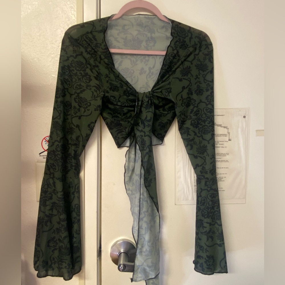 Sheer green and black tie front crop top with bell sleeves which sleeves